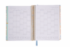 Open spiral-bound planner with grid layout on white background