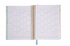 Open spiral-bound planner with grid layout on white background